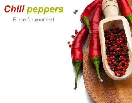 chili peppers and peppercorns in wooden csoop