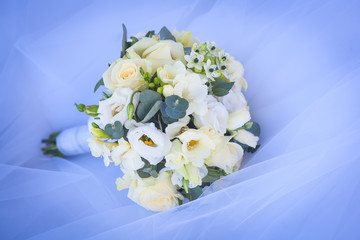 wedding bouquet on the white wedding dress