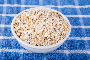 Dry Oatmeal in White Bowl on Blue Towel