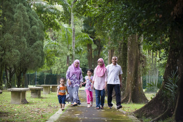 malay muslim family having fun in the park