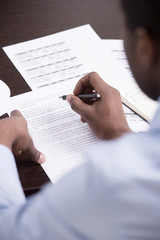 Checking the documents. Top view of African descent men writing