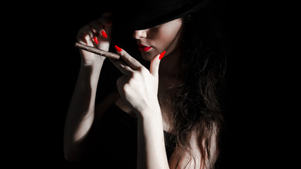 young woman with black hat, cigarillo and red nails