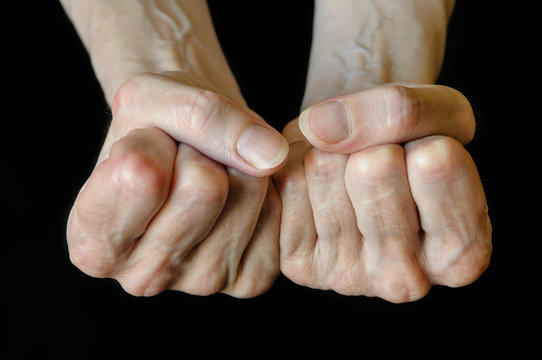 Senior woman showing fists on black background