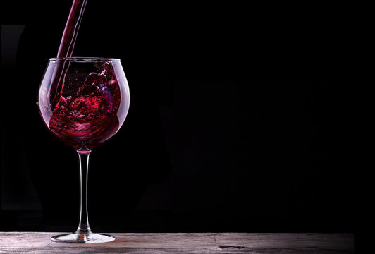 Elegant red wine glass in black background