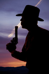 Cowboy silhouette blow end of pistol