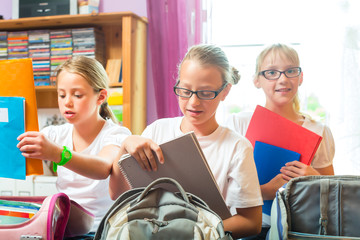 Mädchen packen Ranzen für Schule