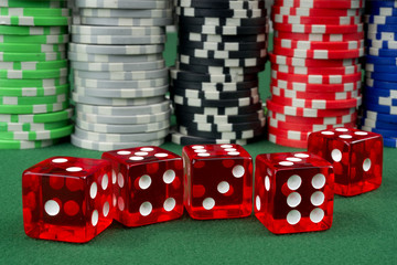 Red dice and chips on a green felt