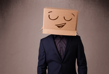 Young man gesturing with a cardboard box on his head with smiley