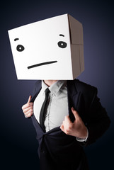 Businessman gesturing with a cardboard box on his head with stra