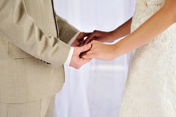 Bride and groom holding his hands