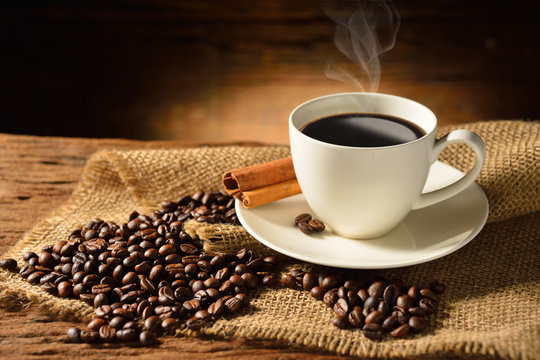 Coffee cup and coffee beans on old wooden background