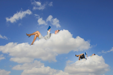 Businesswomen lying on clouds