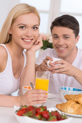 Obraz na płótnie Canvas Having breakfast together. Young loving couple having breakfast