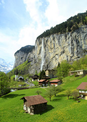 mountain village with church and waterfall, Alps, Switzerland .