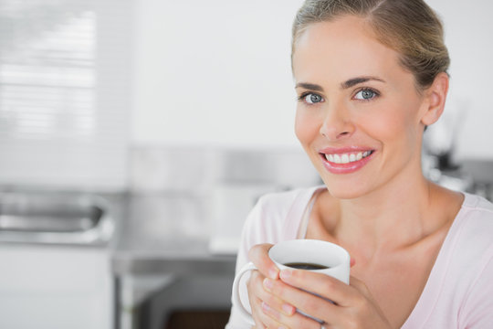 Radiant blonde woman holding coffee