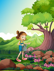 Obraz na płótnie Canvas A girl watering the plants near the rocks