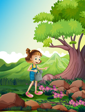 A girl watering the plants near the rocks