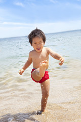 楽しそうに海で遊ぶ男の子