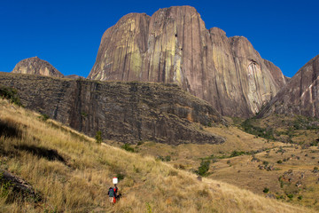 Fototapeta premium Malagasy porters under the Tsaranoro cliff face.