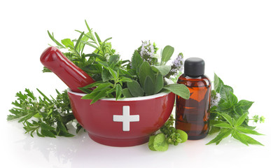 Mortar with medicine cross, fresh herbs and essential oil bottle