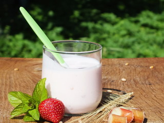 yogurt with fruit on a board made ​​of oak wood in the garden