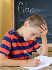 Young boy tries to do his homework