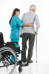 Senior care. Confident nurse helping senior men to walk while is