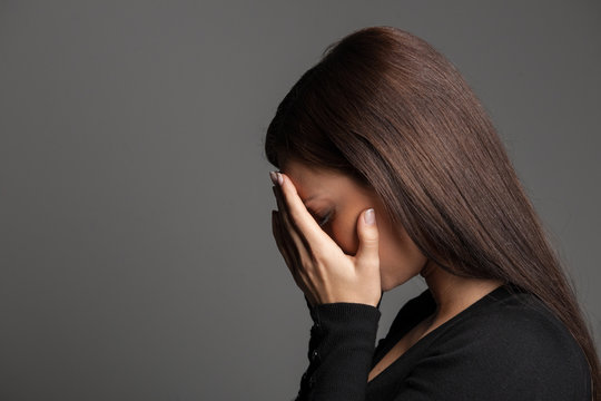 Women crying. Side view of young women crying and hiding face in