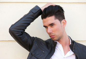 Portrait of a handsome young man with hand in hair