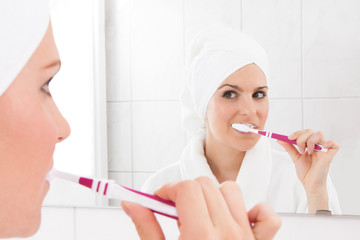 Young woman brushing teeth