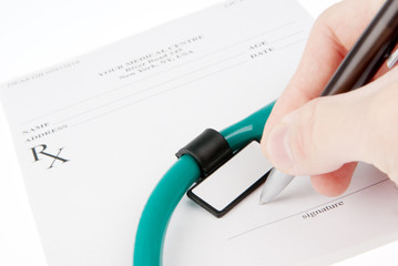 Doctor filling in empty medical prescription with stethoscope