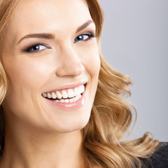 Naklejka premium Young cheerful smiling woman, on gray