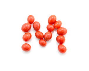 Tomatoes in shape of letter isolated on white