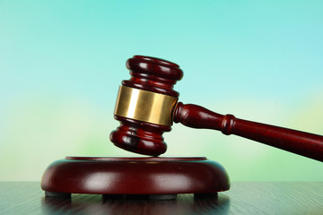 Judges gavel on wooden table on light background