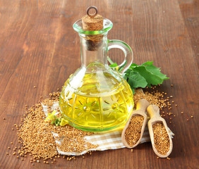 Jar of mustard oil and seeds with mustard flower