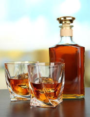 Glass of whiskey with bottle, on dark background
