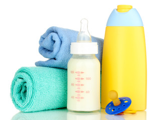 Bottle of milk, pacifier, shampoo and towel isolated on white