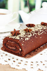 Sweet roll with cup of tea on table in room