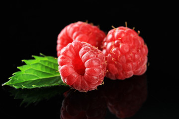 Ripe sweet raspberries on dark background