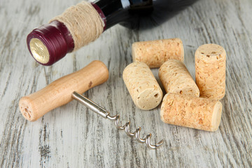 Corkscrew with wine corks and bottle of wine
