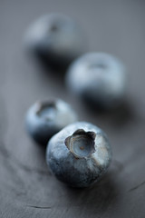 Vertical shot of blueberries on wooden boards, shallow DOF