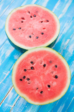 Vertical shot of halved watermelon on wooden background