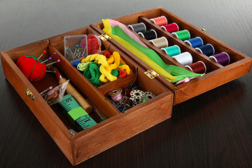 Sewing kit in wooden box on wooden table