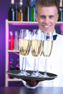 Bartender holding tray with champagne glasses
