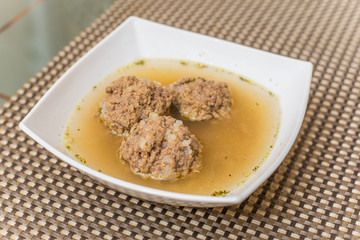 Plate of soup with meatballs
