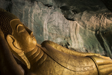 Reclining golden Buddha in the cave