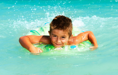 Fototapeta na wymiar Happy Child Playing in Swimming in Sea. Summer Vacations Concept