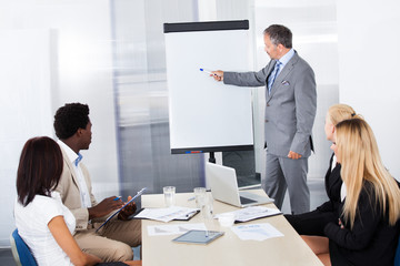 Businesspeople Looking At Man Explaining