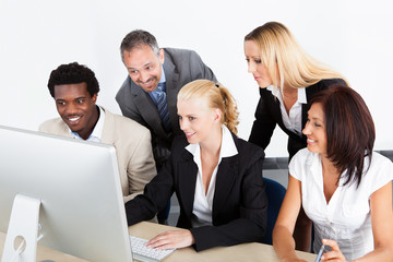 Group Of Businesspeople Looking At Computer