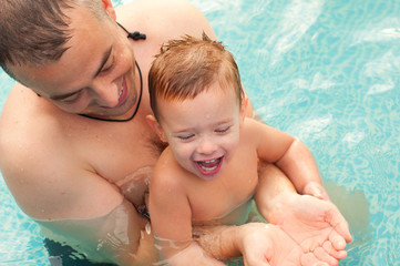 Father and son having fun in the swimming pool